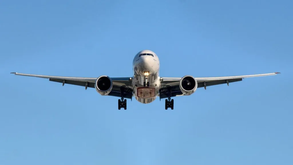 Flugzeug im Flug direkt von vorne mit blauem Himmel