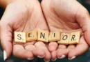 Zwei ältere Hände formen eine Schal und halten Dominosteine mit dem Wort Senior