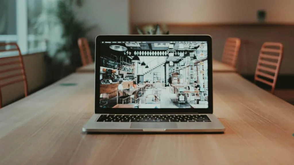 Ein Laptop steht mitten auf einem Schreibtisch in einem großen Besprechungsraum