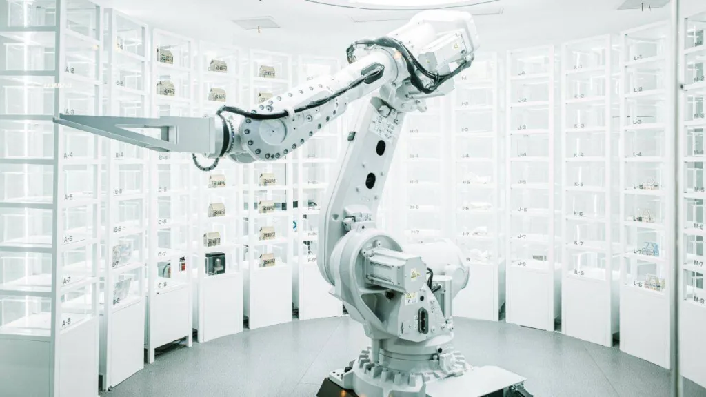 Industrieller Roboterarm in heller Labor- oder Forschungsumgebung mit transparenter Architektur im Hintergrund