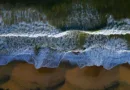 Meeresbrandung mit Wellen am Strand in der Draufsicht