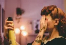 Eine Frau hält sich die hand vor die Augen und benutzt Haarspray für ihr Pony