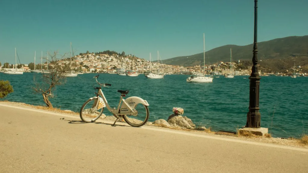 Fahrrad am Wasser geparkt, im Hintergrund Segelschiffe