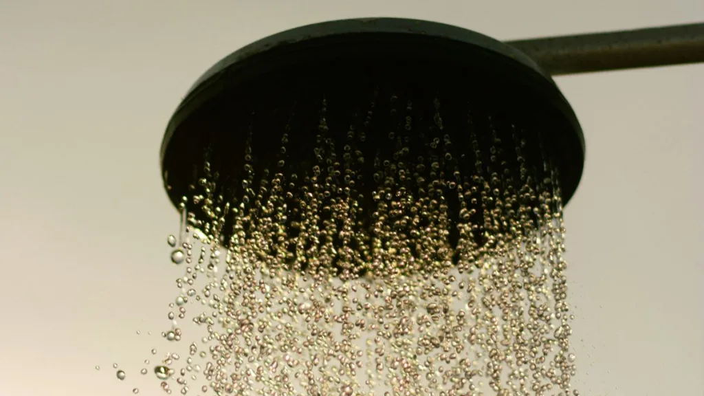 Wasser tropft aus einem Duschkopf