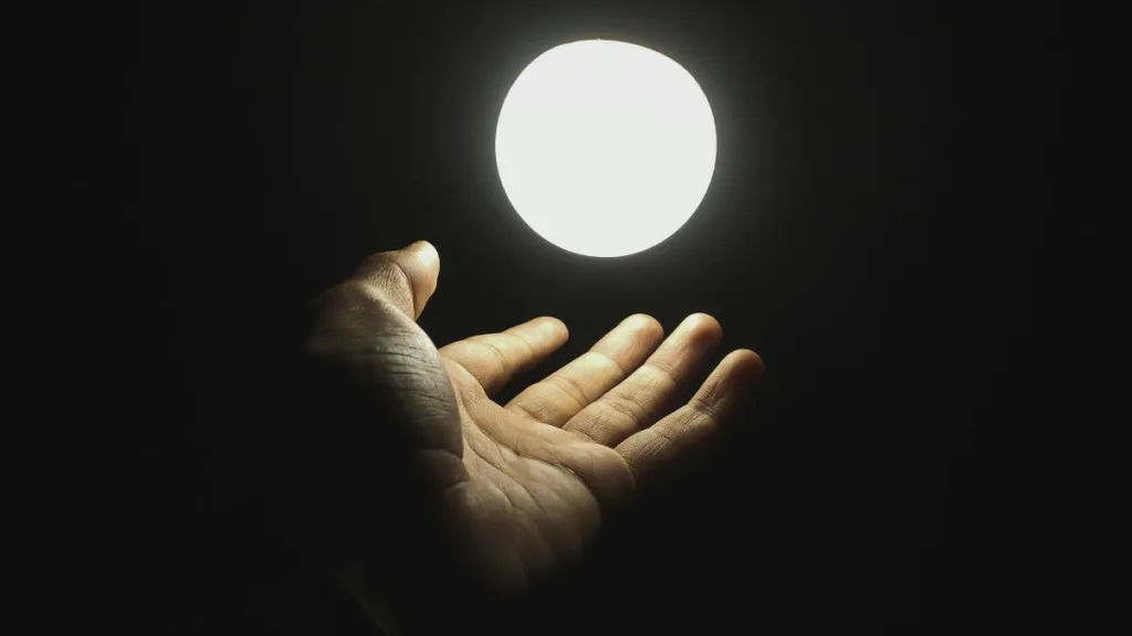 Hand greift nach einem Licht