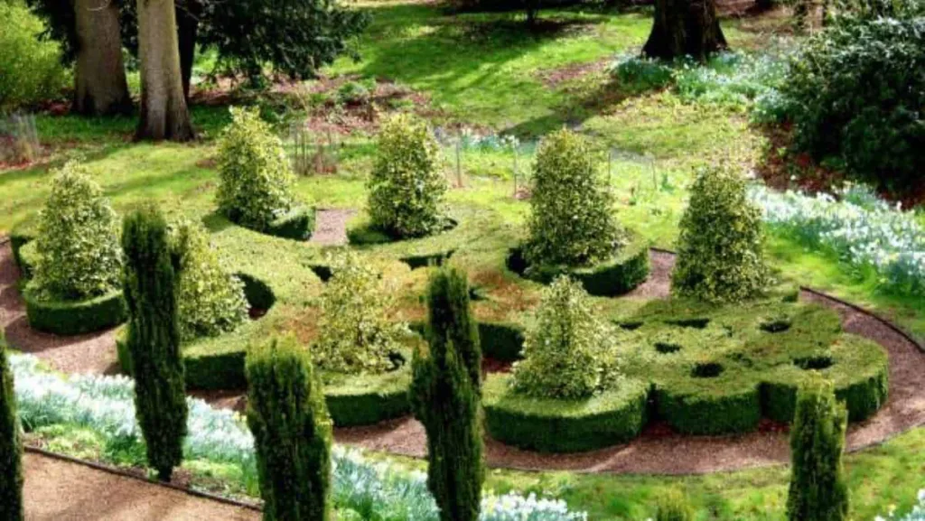Formgeschnittene Gartenhecken und Pflanzenarrangement in einer Grünanlage