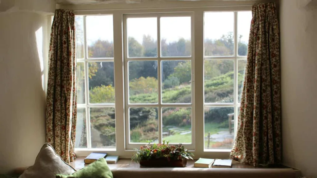 Blick von innen nach außen durch ein Fenster im Landhausstil