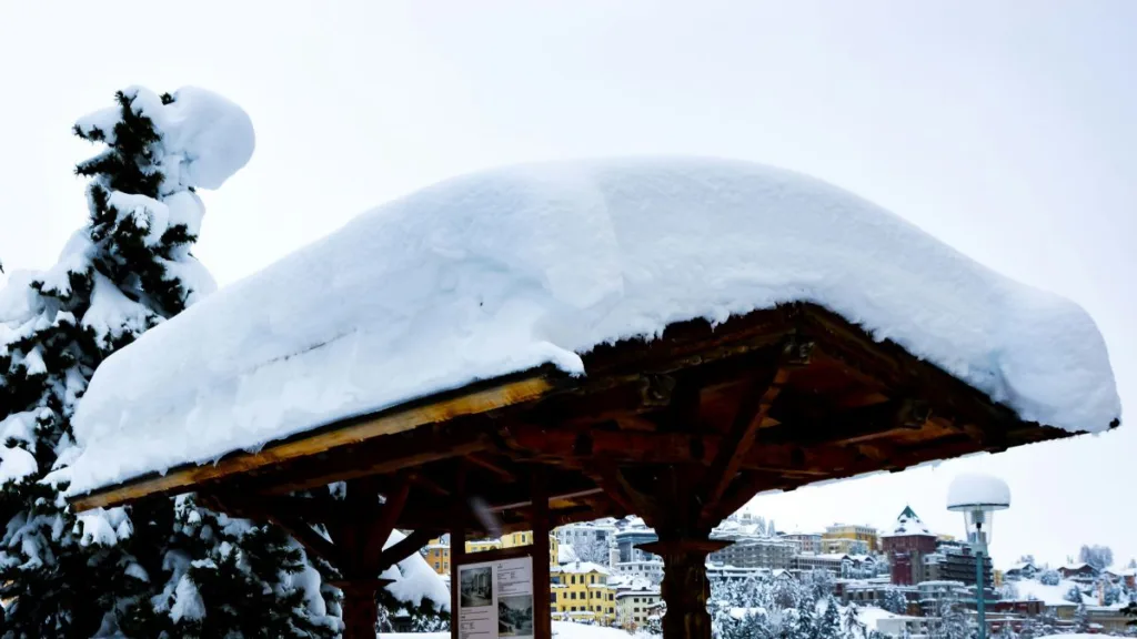 viel Schnee auf einem Dach aus Holz
