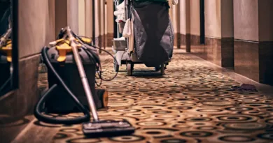 ein älterer Hotelflur mit einem Reinigungswagen und einem Staubsauger