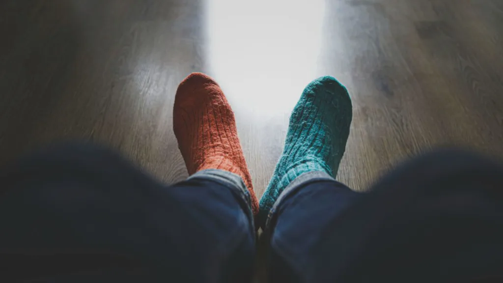 ansicht zweier Füße mit einer roten und einer grünen Socke