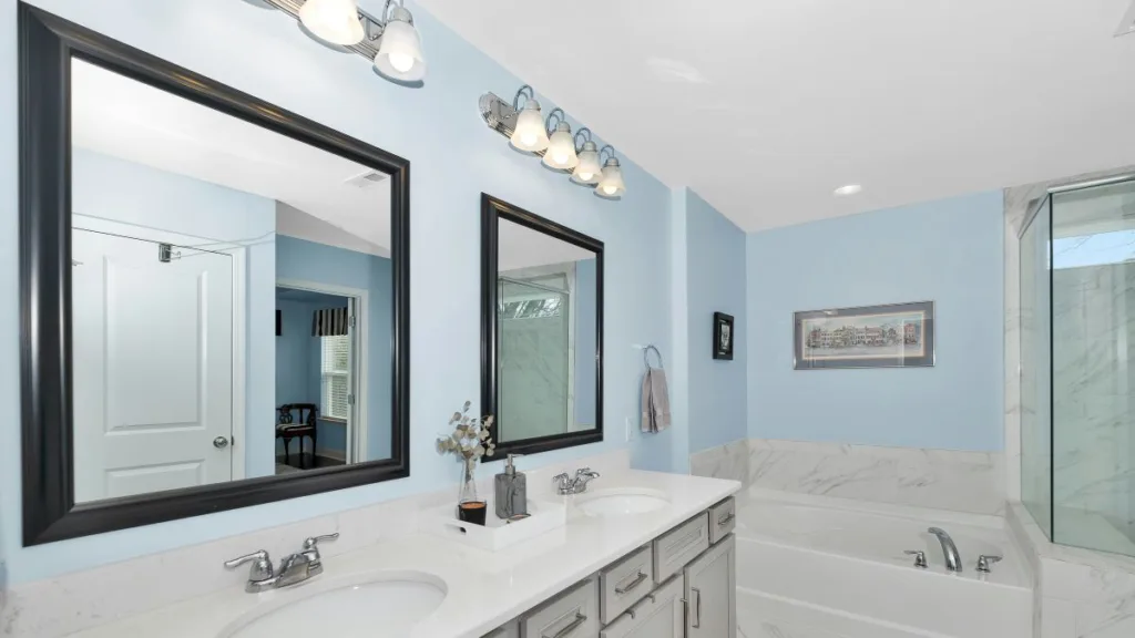 ein Badezimmer mit zwei Spiegeln mit kleineren Alltagshilfen