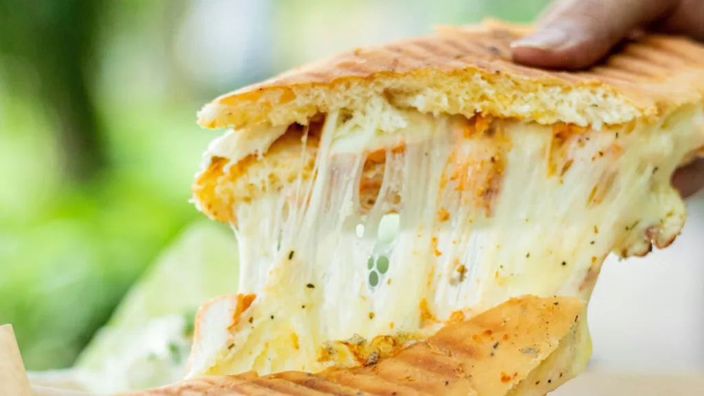 ein aufgeschnittenes Panini mit zerlaufenden Käse