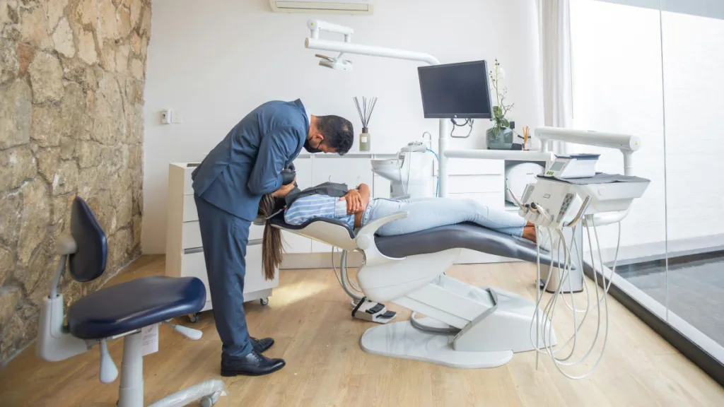 ein Zahnarzt behandelt eine Patientin auf dem Zahnarztstuhl