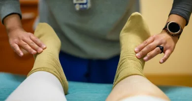 zwei Hände massieren zwei Füße mit Socken