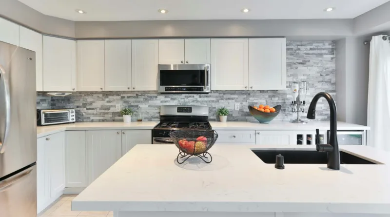 Ansicht einer modernen weißen Küche mit Kochinsel und Küchengeräten