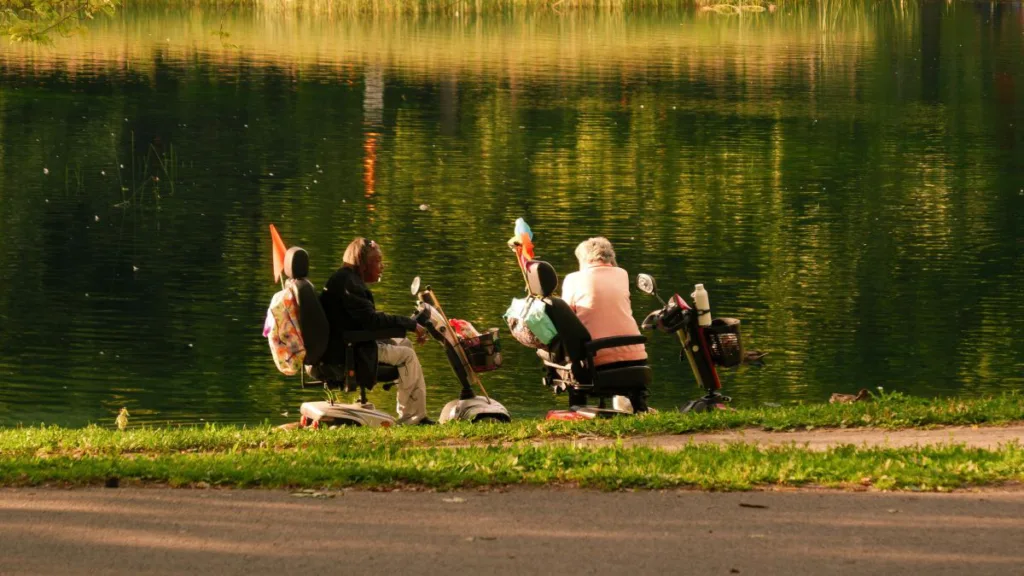 Zwei Frauen in ihren Elektrorollern am See