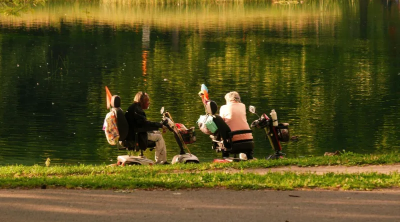 Zwei Frauen in ihren Elektrorollern am See