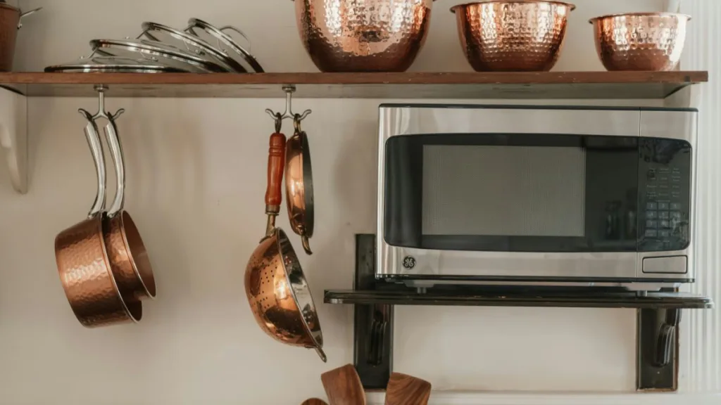 eine alte silberne Solo-Mikrowelle auf einem Wandregal