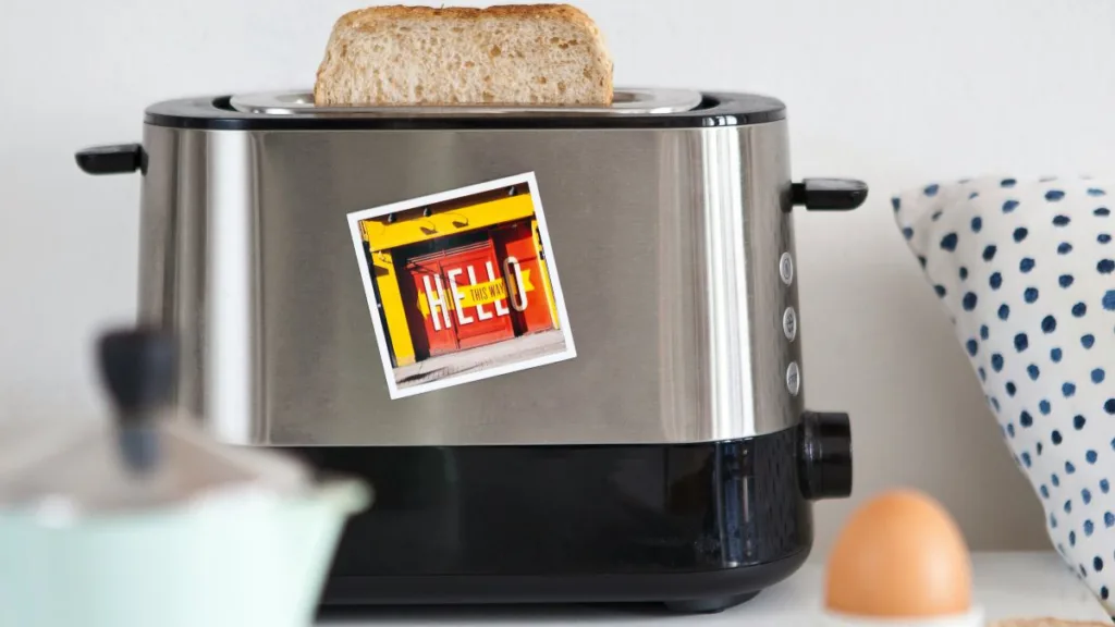 ein alter Toaster mit einem Aufkleber, ein Toast schaut raus und ein Frühstücksei steht davor