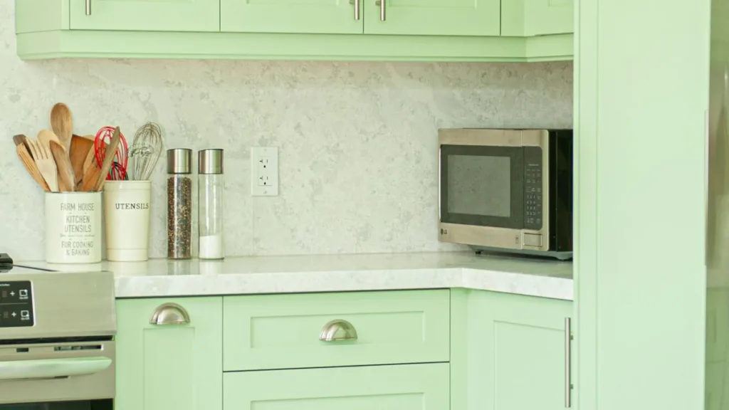 eine Mikrowelle steht in der Ecke einer grünen Küche