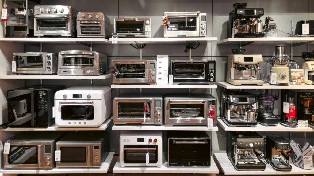 viele Mikrowellen mit Grill stehen in einem Regal an der Wand