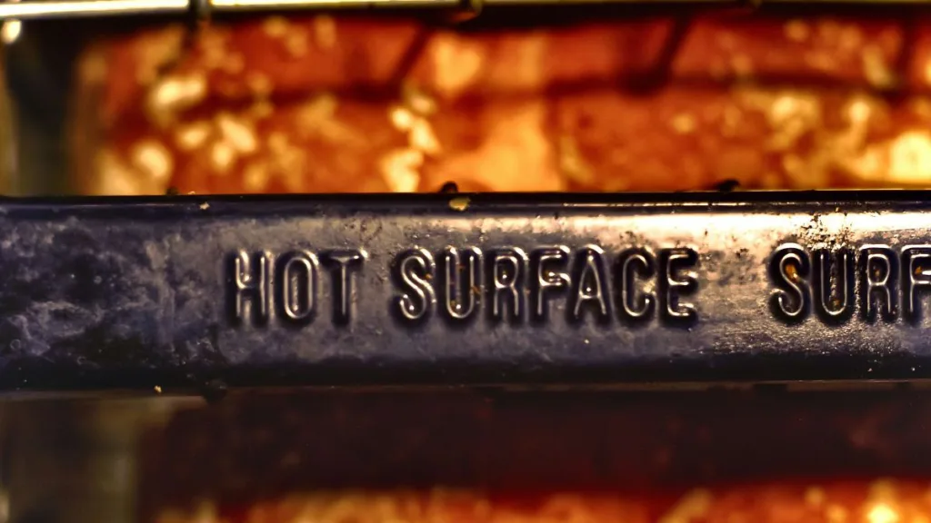 Blick von oben in einen Toaster, die Aufschrift HOT SURFACE ist zu erkennen