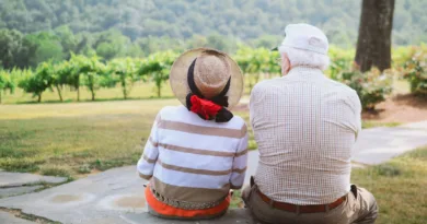 ein älteres Pärchen sitzt und schaut in richtung eines Weinberges