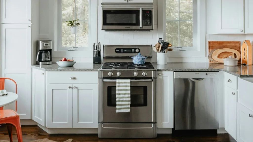 eine weiße Küche im Landhausstil mit Herd und Mikrowelle