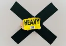 ein schwarzes kreuz und in der Mitte steht Heavy