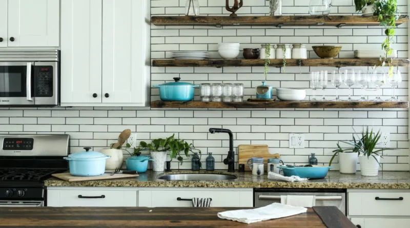 eine Landhausküche mit Regalen und Kräutern neben der Spüle