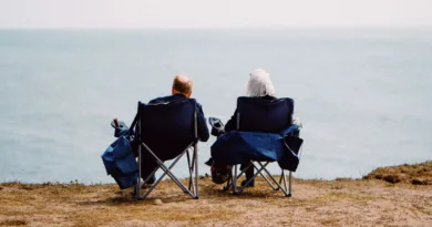 Mobile Aufstehhilfen im Überblick – Standfestigkeit, Gewicht und Grenzen zwei Rentner sitzen in Klappstühlen und schauen aufs Meer