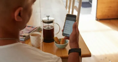 Blutdruckmessgeräte mit App – Bluetooth, WLAN und EKG-Funktionen erklärt ein Mann schaut während des Frühstücks auf sein Handy und schaut sich seine Gesundheitsdaten an