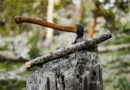 ein Beil steckt in einem Baumstumpf mitten im Wald