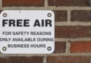 ein Schild an einer Häußerwand auf dem steht „Kostenlose Luft – aus Sicherheitsgründen nur während der Geschäftszeiten verfügbar.“