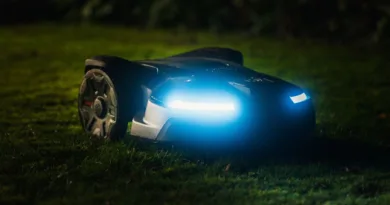 ein Rasenmähroboter in der Nacht mit Scheinwerfern