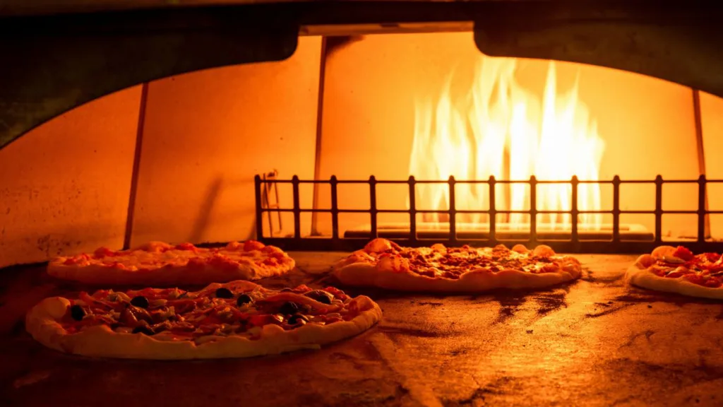 das innere eines Gas-Pizzaofens mit 4 Pizzen drin