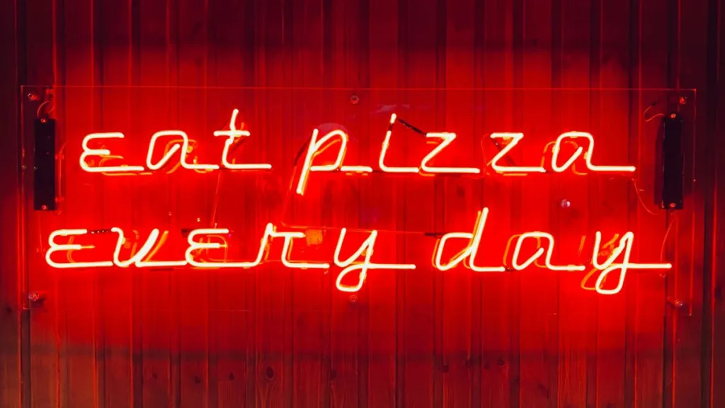 ein rotes Neonröhren-Reklameschild mit "eat pizza every day"