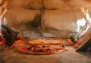 zwei Pizzen garen gerade in einem Holzofen