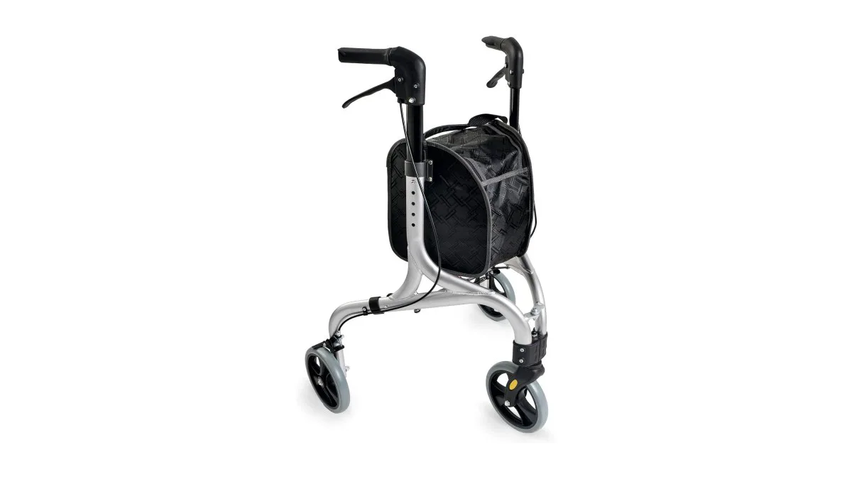 Leichter Weinberger Dreirad‑Rollator, kompakt zusammengeklappt neben einer Tür