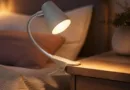 Moderne Klemmlampe an Nachttischkante mit warmem Leselicht