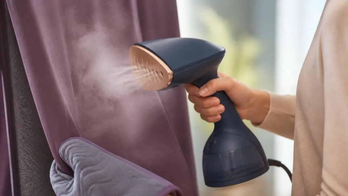 Philips Steamer in Gebrauch, Metallplatte und Dampf sichtbar, Handschuh und StyleMat daneben